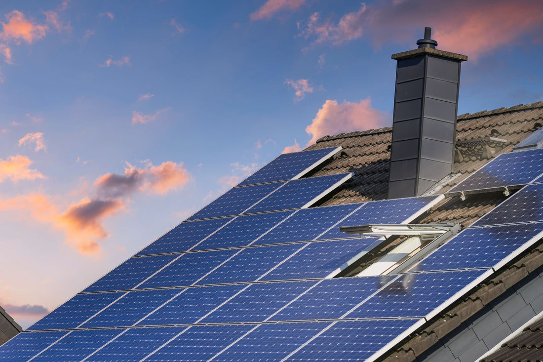 Solaranlage auf grauem Dach vor einem Sonnenuntergang